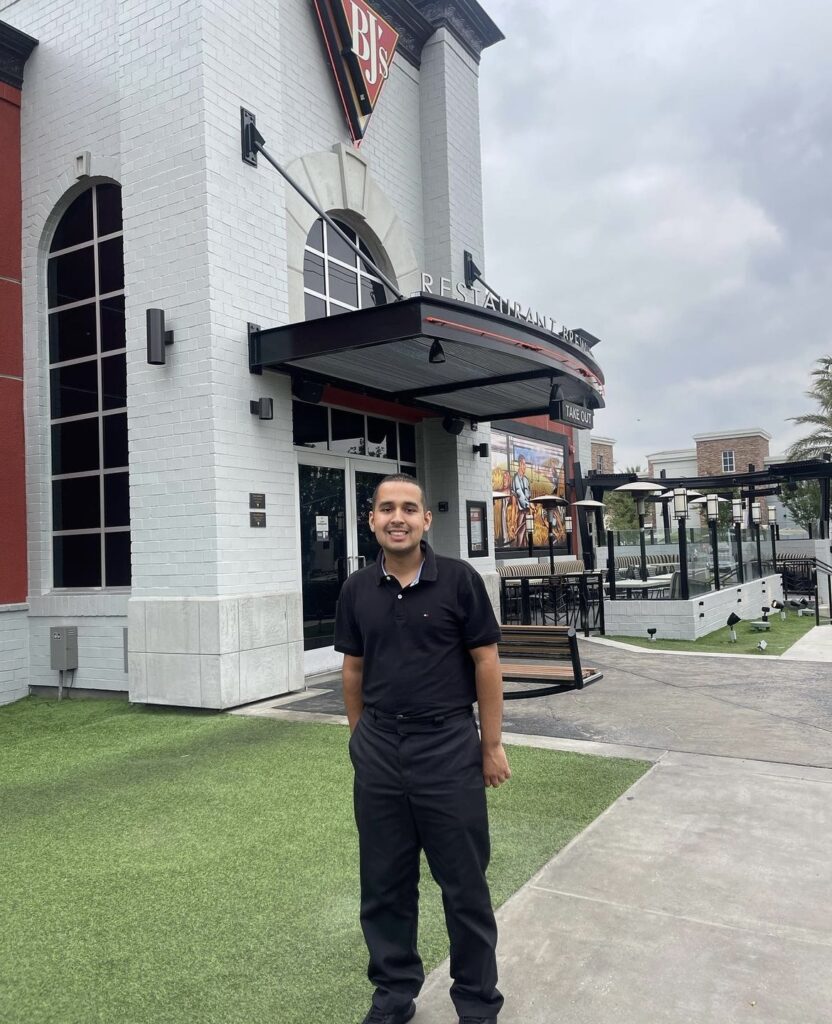 smiling man outside of restaurant